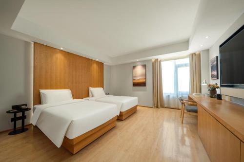 无锡无锡滨湖区体育中心亚朵X酒店的酒店客房设有两张床和一台平面电视。