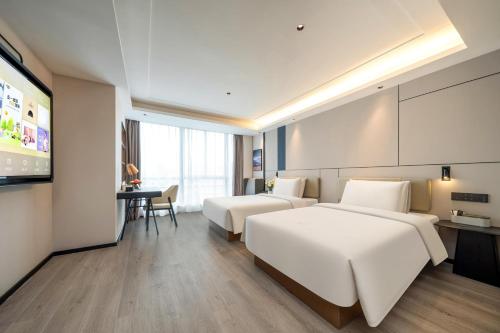 杭州杭州文一路亚朵X酒店的酒店客房设有两张床和电视。