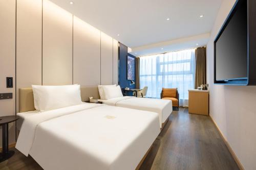 延吉延吉百货大楼西市场亚朵X酒店的酒店客房设有两张床和一台平面电视。