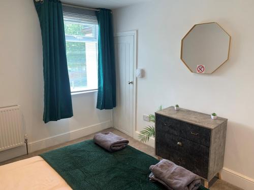奥萨格Alsager Town Centre Apartment的一间带镜子、一张床和梳妆台的卧室