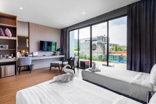 卡马拉海滩New Luxury Two bedroom private swimming pool villa with complete supporting facilities, convenient for travel 800 meters to Kamala Beach H09的酒店客房设有两张床和大窗户。