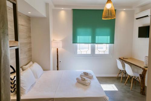 卡利斯托斯Ammos Luxury Suite的一间卧室配有一张床,上面有两条毛巾