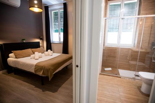塞维利亚Apartamentos Doña Concha的一间卧室配有一张床,浴室设有淋浴。