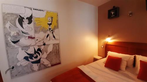 卡尼略MARVEL的卧室配有一张床,墙上挂有绘画作品