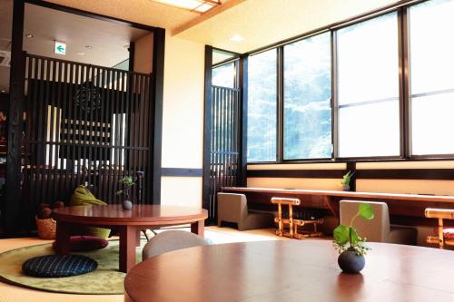 箱根Onsen Guest House Tsutaya的客房设有桌椅和窗户。