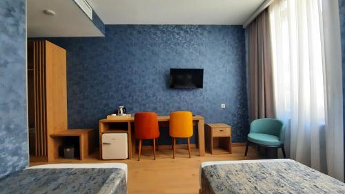 第比利斯Hotel DownTown Avlabari的配有桌椅和蓝色墙壁的客房