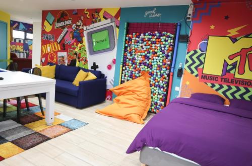 蒙斯Capsule 90's - Jacuzzi - Sauna - Flipper - Billard - Netflix - Nintendo Switch & Jeux -的儿童房设有床和电视