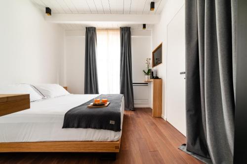 孔韦尔萨诺Arringo - Stay comfy的一间卧室,配有一张床,上面放着橙子托盘