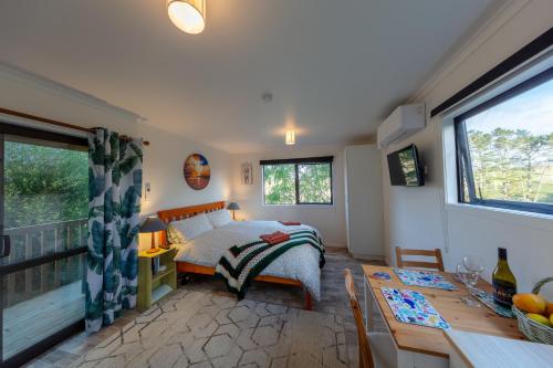 PatauaCountry Nirvana的一间卧室配有一张床铺和一张桌子,还有一间用餐室