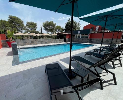 穆昂萨尔图Urban Style Cannes Mouans-Sartoux - Piscine Extérieure - Parking Gratuit的游泳池旁的2把躺椅和遮阳伞