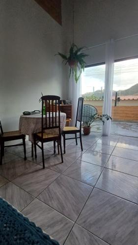 卡瓦坎特Casa Da Ju Cavalcante的客厅配有桌子、两把椅子、一张桌子和一张桌子。