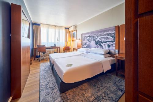 慕尼黑奥林匹亚公园安娜艺术酒店的配有一张床和一张书桌的酒店客房