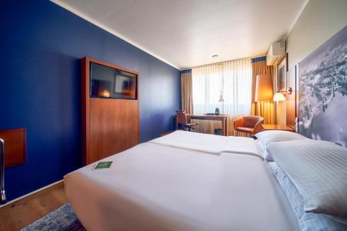 慕尼黑奥林匹亚公园安娜艺术酒店的酒店客房设有两张床和蓝色的墙壁。