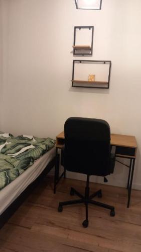 格但斯克Apartament Portowa OSTOJA的一间卧室配有一张桌子和一张椅子,位于床边