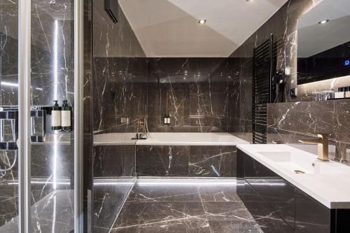 塞兰Van der Valk Golfhotel Serrahn - Adult Only的带淋浴、盥洗盆和浴缸的浴室