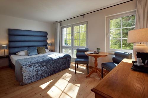 塞兰Van der Valk Golfhotel Serrahn - Adult Only的卧室配有一张床和一张桌子及椅子
