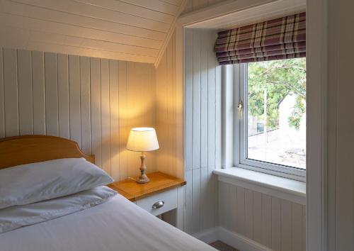 格伦科Duart Cottage的一间卧室设有一张床和一个窗口