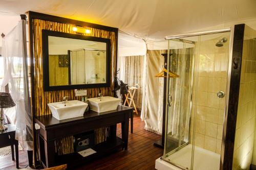 龙杜Taranga Safari Lodge的一间带两个盥洗盆和淋浴的浴室