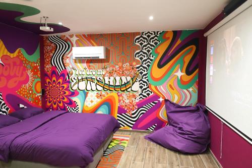 蒙斯Capsule Groovy-Jacuzzi-Sauna-Billard-Netflix- Nintendo Switch & Jeux的客房设有两张床和彩色墙壁。