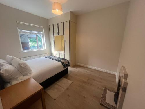戈尔韦Yeats Lodge Self catering Apartment and Bar的一间卧室设有一张床和一个窗口