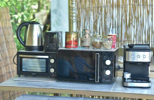 阿赫托波尔Вили Водно Конче Villas Vodno Konche的桌子上设有微波炉和咖啡机。