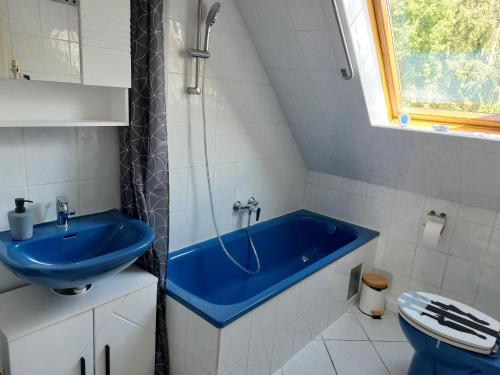 施内沃丁根Wruck,Ferienwohnung的一间带蓝色浴缸和卫生间的浴室