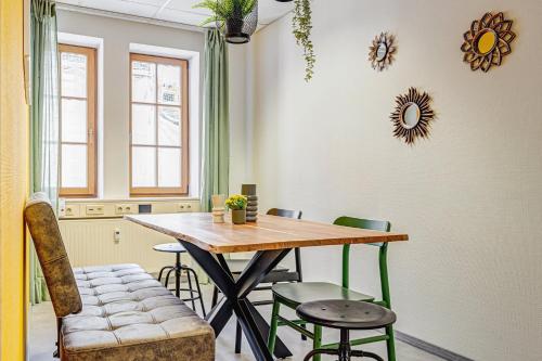 米尔豪森Pressehaus Apartment Obermarkt One的一间带木桌和椅子的用餐室