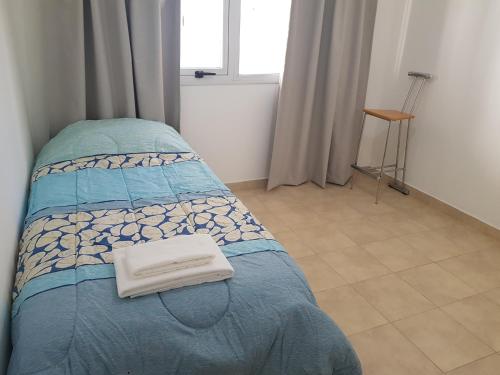 布宜诺斯艾利斯Jazzy-Habitación en Dpto Compartido的一间卧室配有一张床,床上有毛巾