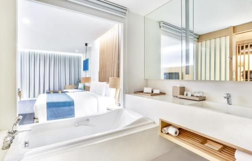 七岩華欣王牌度假村的浴室设有床、浴缸和镜子