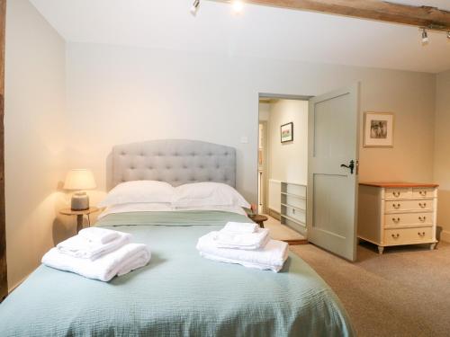 佩特沃斯Hungers Cottage的一间卧室配有一张大床和毛巾