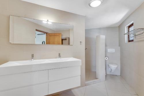 克拉伦代克Bonaire Apartment的白色的浴室设有水槽和镜子