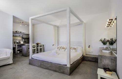 林都斯林典皮尔酒店的一间带白色天蓬床的卧室和一间厨房