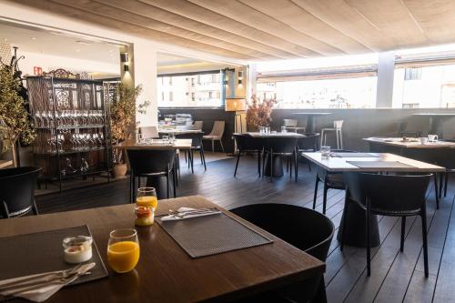 圣克鲁斯-德特内里费阿多尼斯资本酒店的用餐室设有桌椅和窗户。