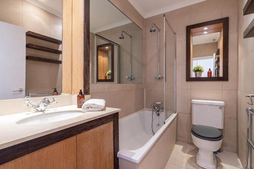 伦敦Stay at Kensington and Knightsbridge的一间带水槽、浴缸和卫生间的浴室