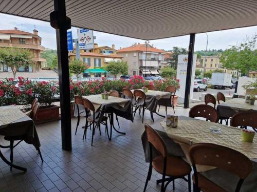 圣马力诺多加纳酒店的一间设有桌椅的餐厅,位于街道上