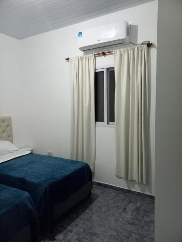 福尔摩沙Portal del Rio的一间卧室配有床和带窗帘的窗户