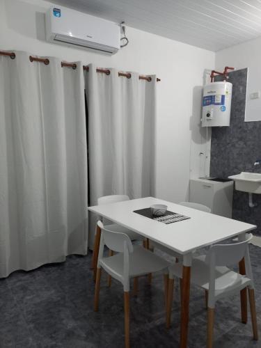 福尔摩沙Portal del Rio的窗帘的房间里一张白色的桌子和椅子