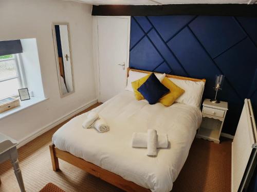 SouldernThe Fox Inn的一间卧室设有一张蓝色墙壁的大床