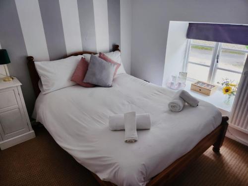 SouldernThe Fox Inn的一张带白色床单和毛巾的床