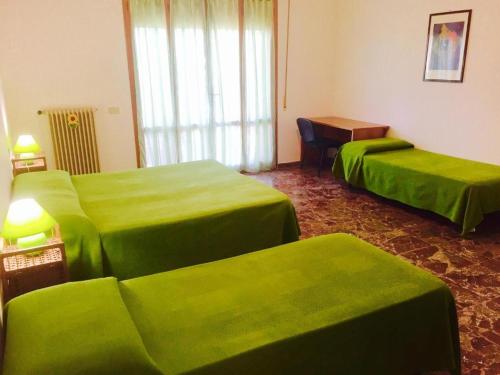比萨B&B Francesco的酒店客房设有两张绿色的床和一张桌子
