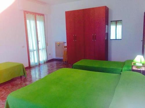 比萨B&B Francesco的一间设有两张绿色床和红色橱柜的房间