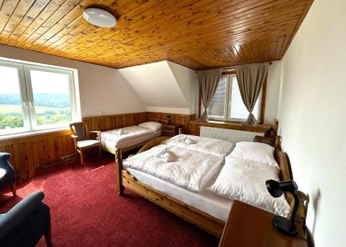 利布韦尔达矿泉村Obří Sud Libverda ***的一间卧室设有两张床和木制天花板