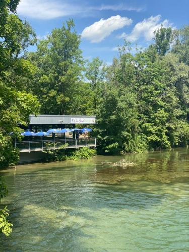 慕尼黑AllYouNeed Oktoberfest Basic Camping的一座桥,在河上,有树在后边