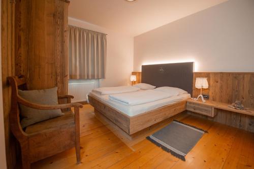 博尔扎诺Steidlerhof的一间卧室配有一张床和一把椅子
