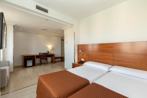 马德里Porcel Torre Garden的配有一张床和一张书桌的酒店客房