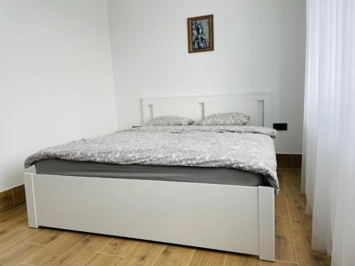 希奥利艾Alto Turtas Apartamentai的白色客房内的一张白色床架