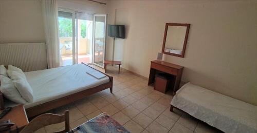 亚历山德鲁波利斯HotelApart Filoxenia的一间卧室配有一张床、镜子和一张桌子
