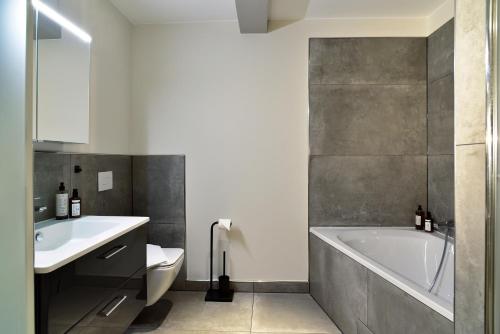 莱比锡SAXX Apartments Leipzig的带浴缸、卫生间和盥洗盆的浴室
