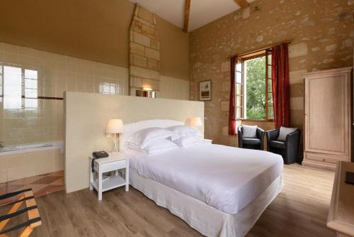 圣日的贡桑斯城堡酒店的卧室配有一张白色大床和两把椅子