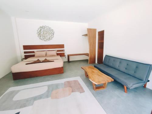 班泰Villa Baan Naí Pã的一间卧室配有一张床和一张蓝色的沙发